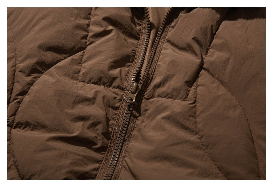 Close-up of the brown jacket's front zipper and stitched fabric panels.