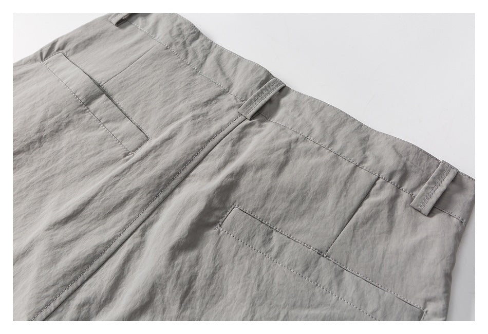 Close-up of gray shorts showing the rear waistband, belt loops, pockets, and stitched seams.