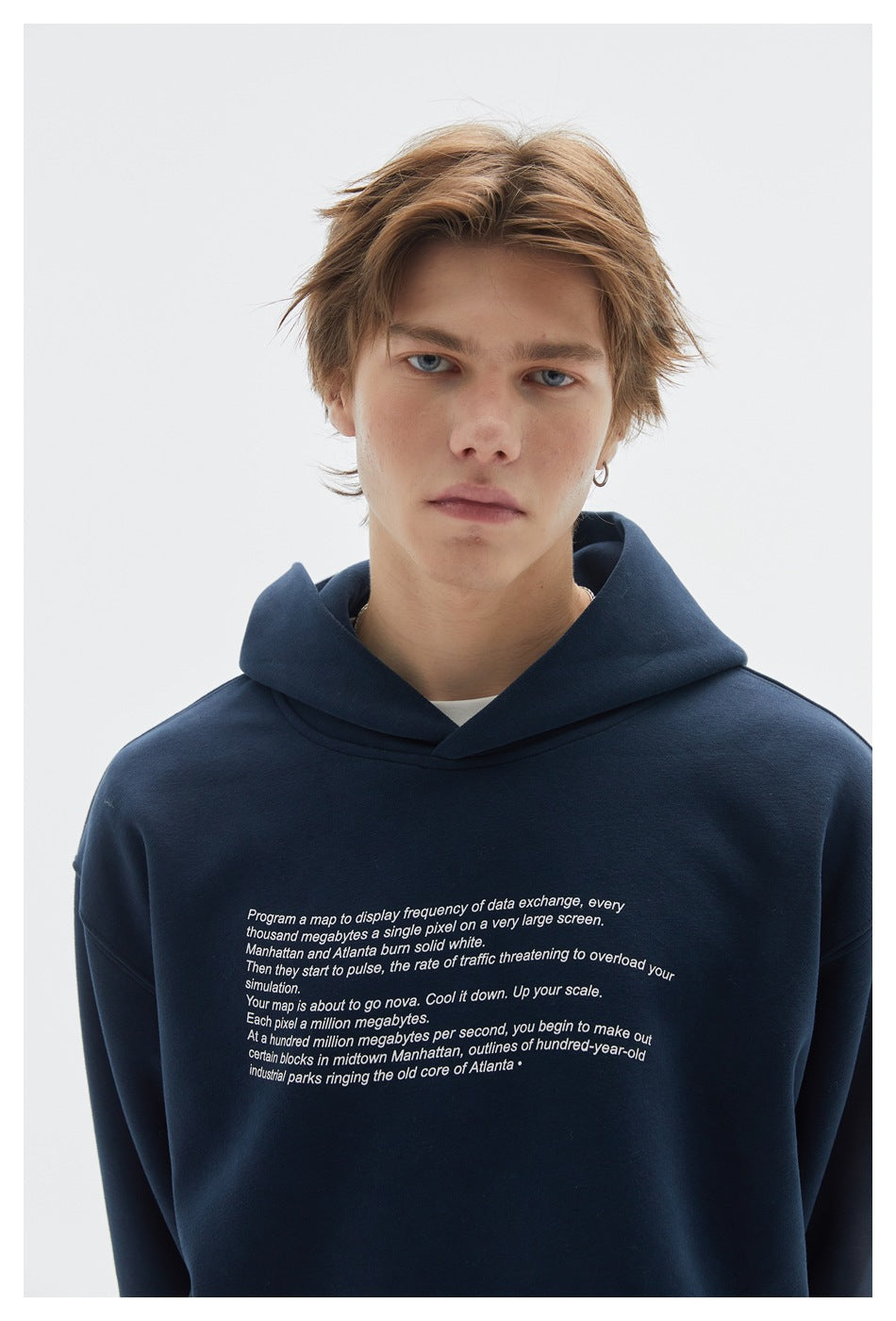 Model wearing a navy hoodie with a large white text print across the chest.