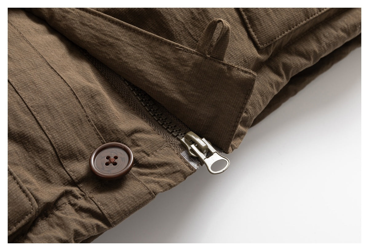 Close-up of a brown jacket's front zipper, button, and protective placket.