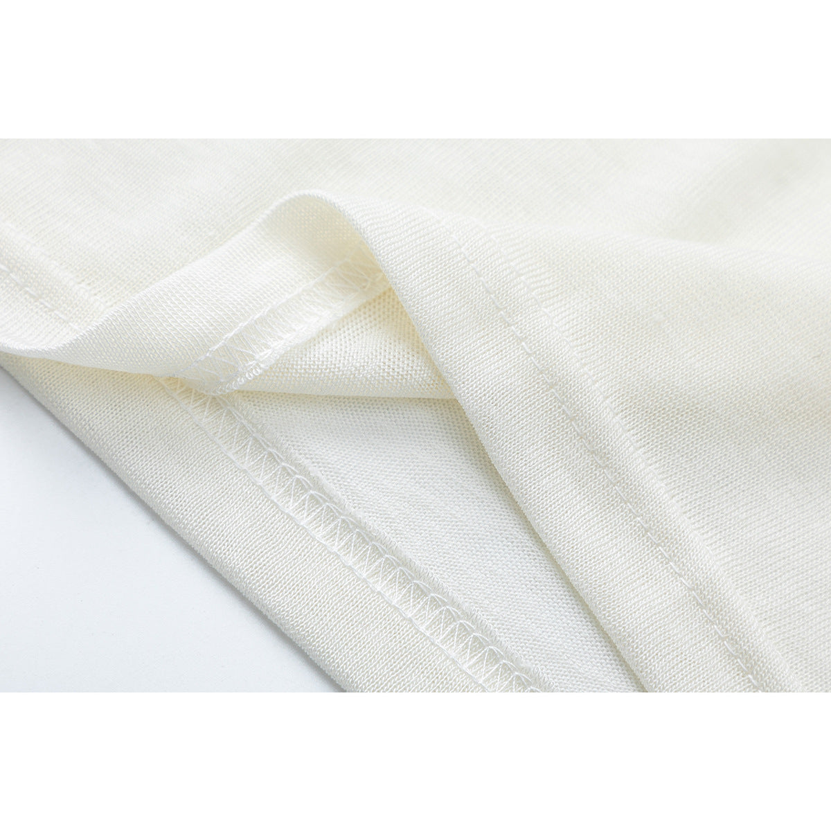 Close-up of the off-white shirt's folded edge and interior stitching.