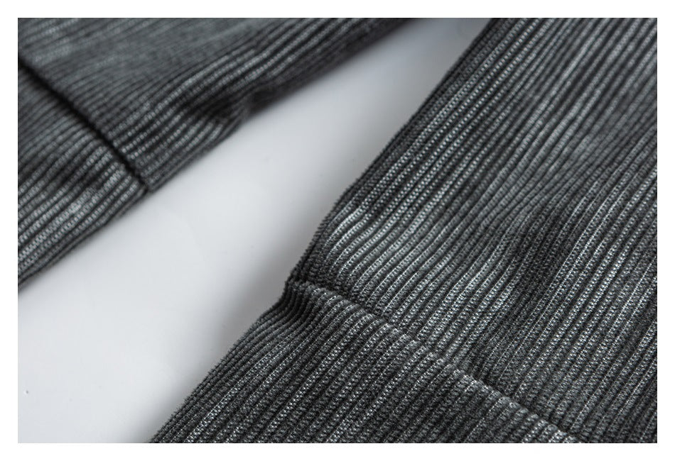 Close-up of gray striped trouser fabric with a stitched seam and folded edge.
