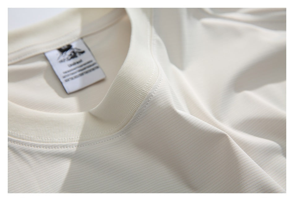 Close-up of a white shirt’s ribbed crew neckline, stitching, and inner label.