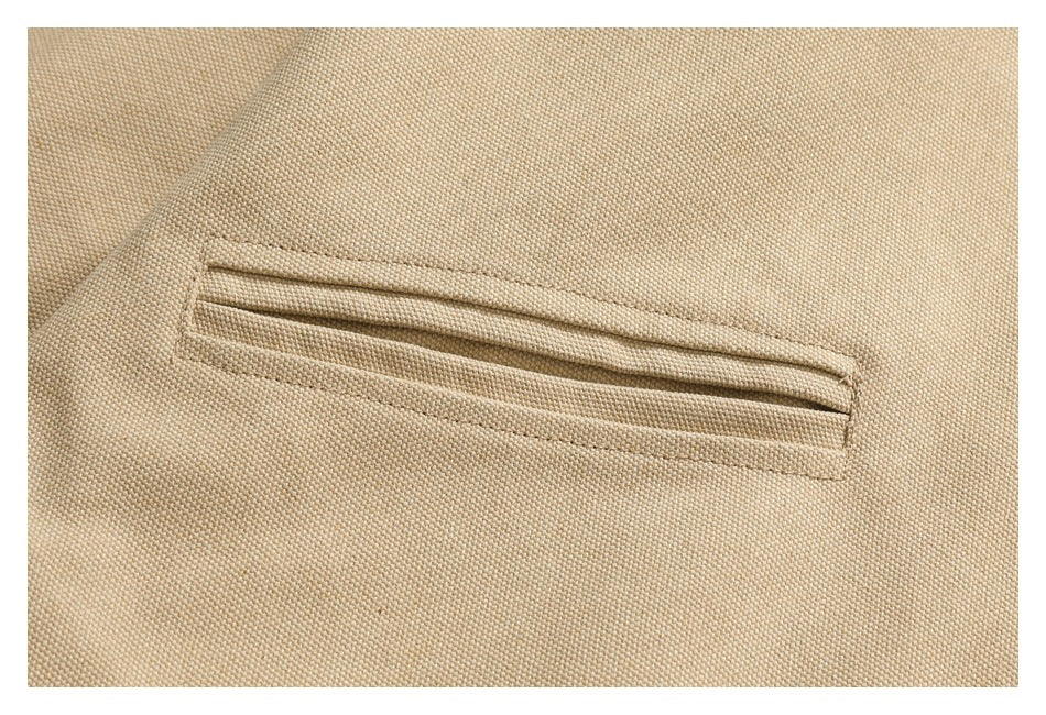 Close-up of a beige textured garment showing a long, narrow welt pocket.