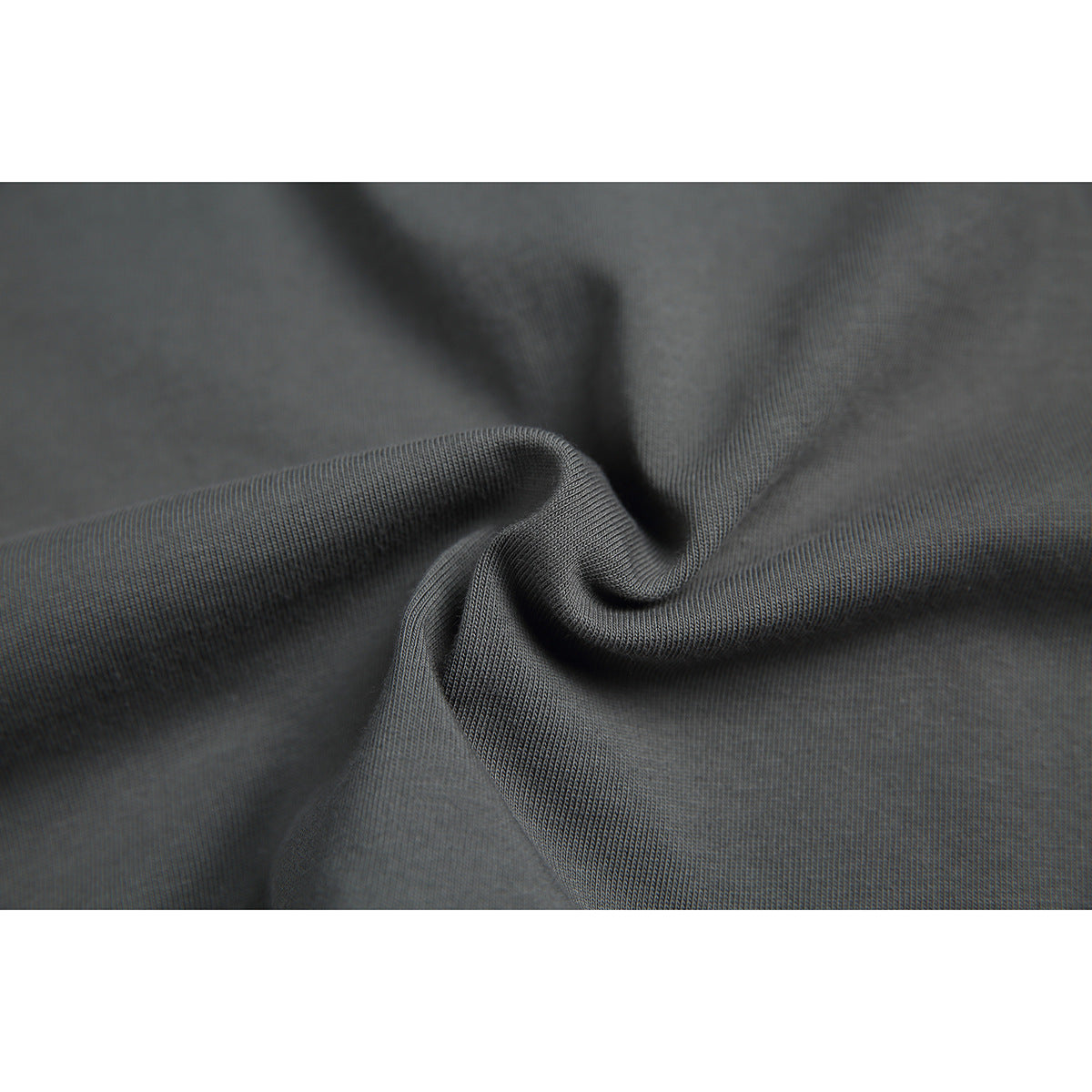 Close-up of charcoal gray knit fabric gathered into folds, showing its surface texture.