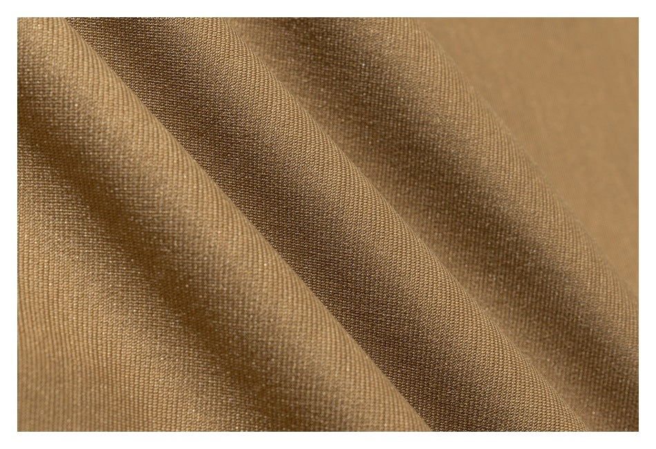Macro view of brown garment fabric showing its woven texture and folds.