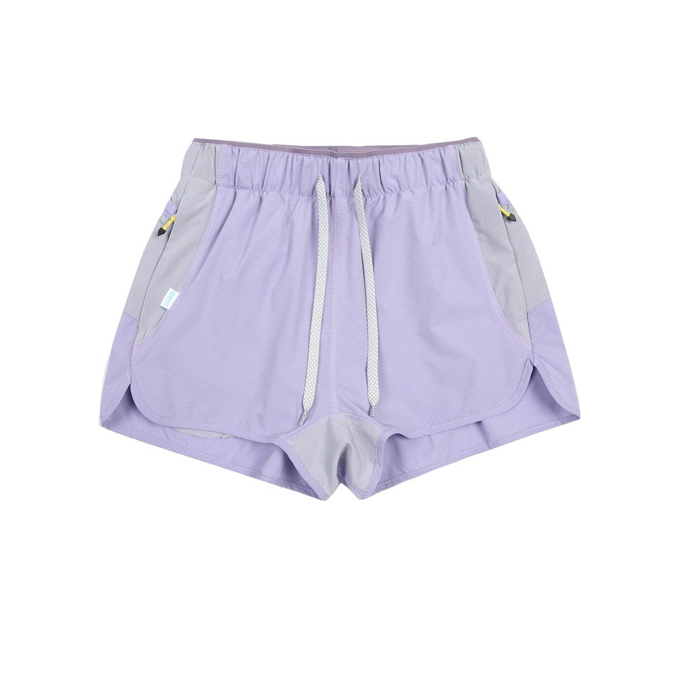 Light purple shorts with white drawstring, gray side panels and curved split hems, flat lay