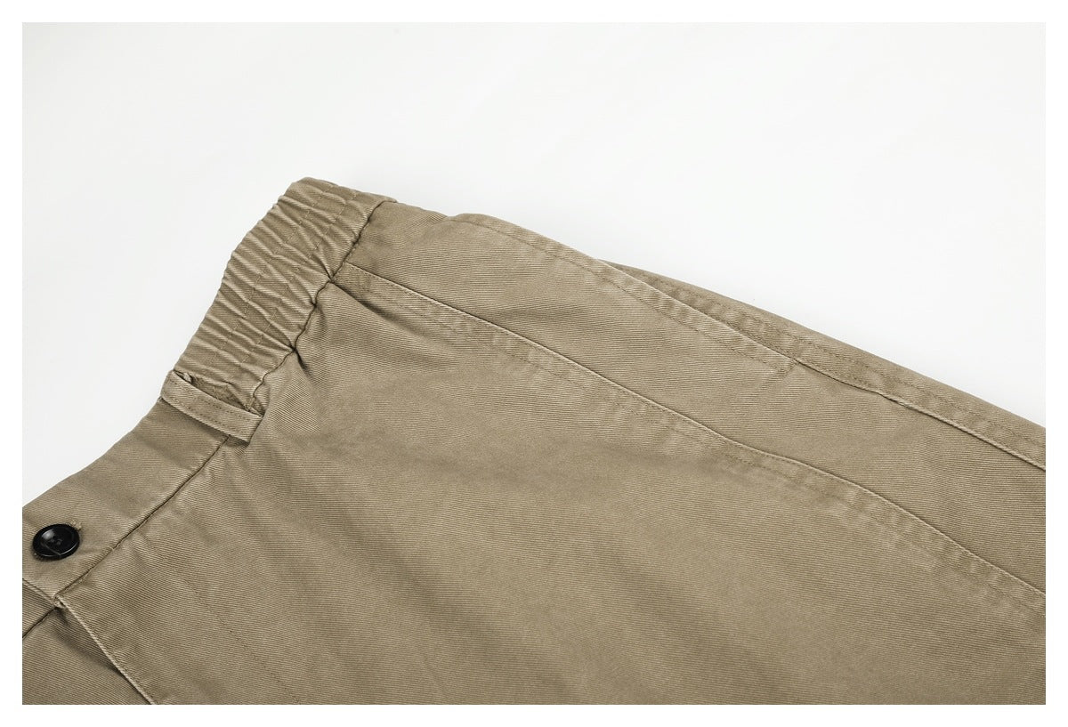 Close-up of beige pants showing the elasticated waistband and stitching.