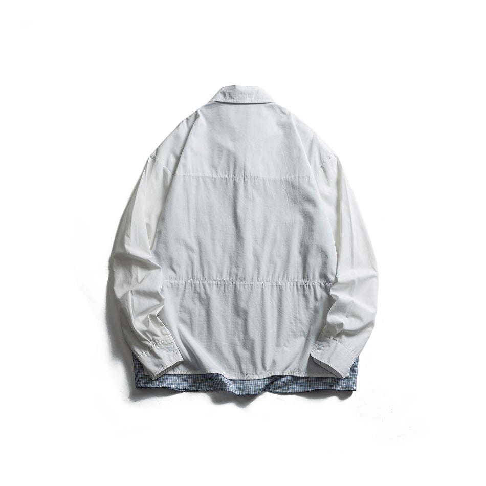 Back view of a white button-up shirt laid flat, with blue plaid lining visible at the hem.