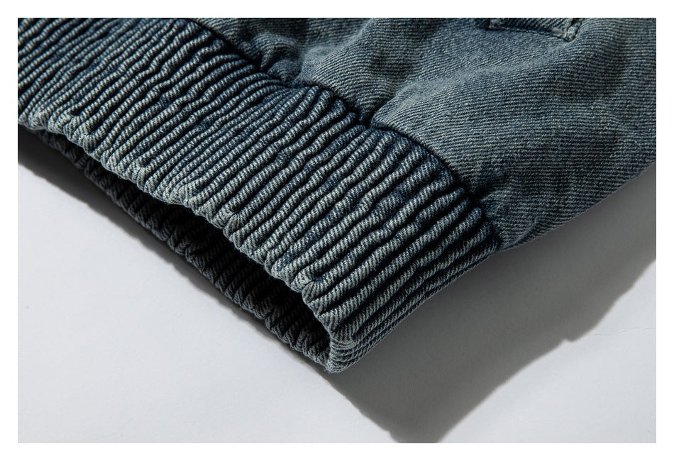 Close-up of a wide ribbed blue-gray denim hem with gathered fabric above it.