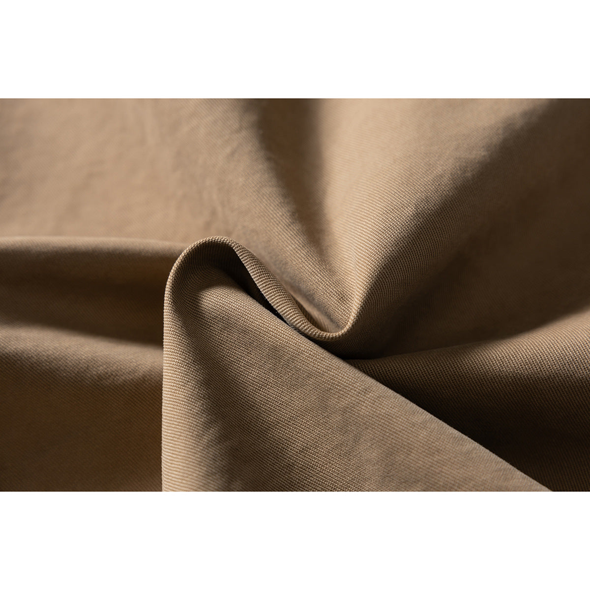 Macro view of tan woven fabric folded to show its surface and texture.