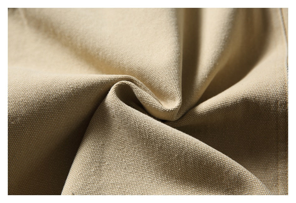 Close-up of beige woven fabric draped in soft folds, showing its textured surface.