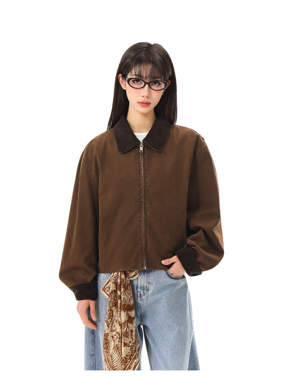 Closer front view of a model wearing a brown cropped zip jacket with a dark collar and cuffs.