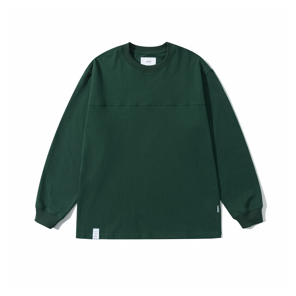 Dark green crew neck long sleeve top flat lay with ribbed collar and cuffs and a yoke seam across the chest