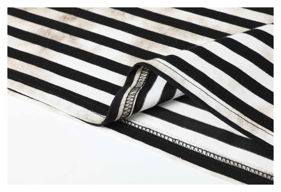 Close-up of the black-and-white striped garment hem, showing its folded edge and overlock stitching.