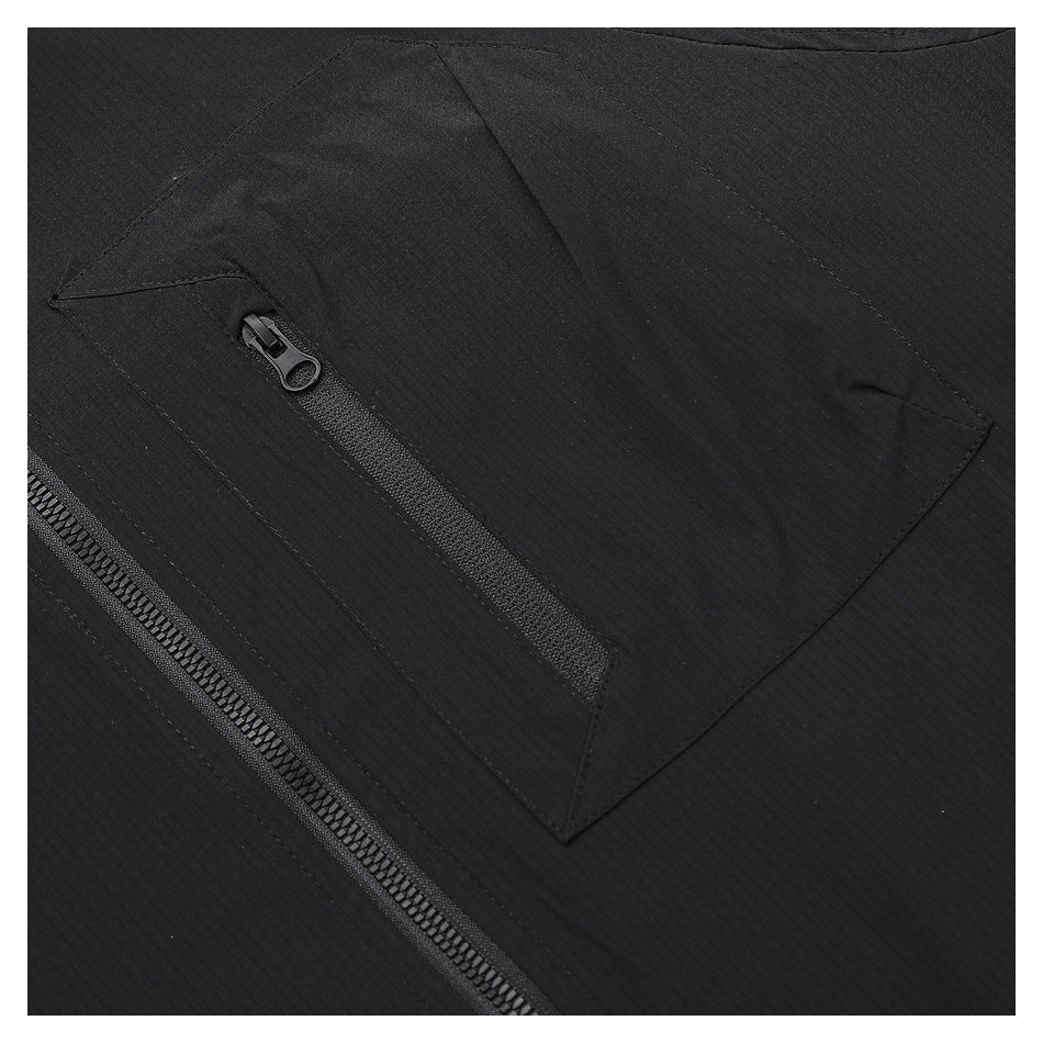 Close-up of a black garment with a diagonal zip pocket and a larger zipper nearby.