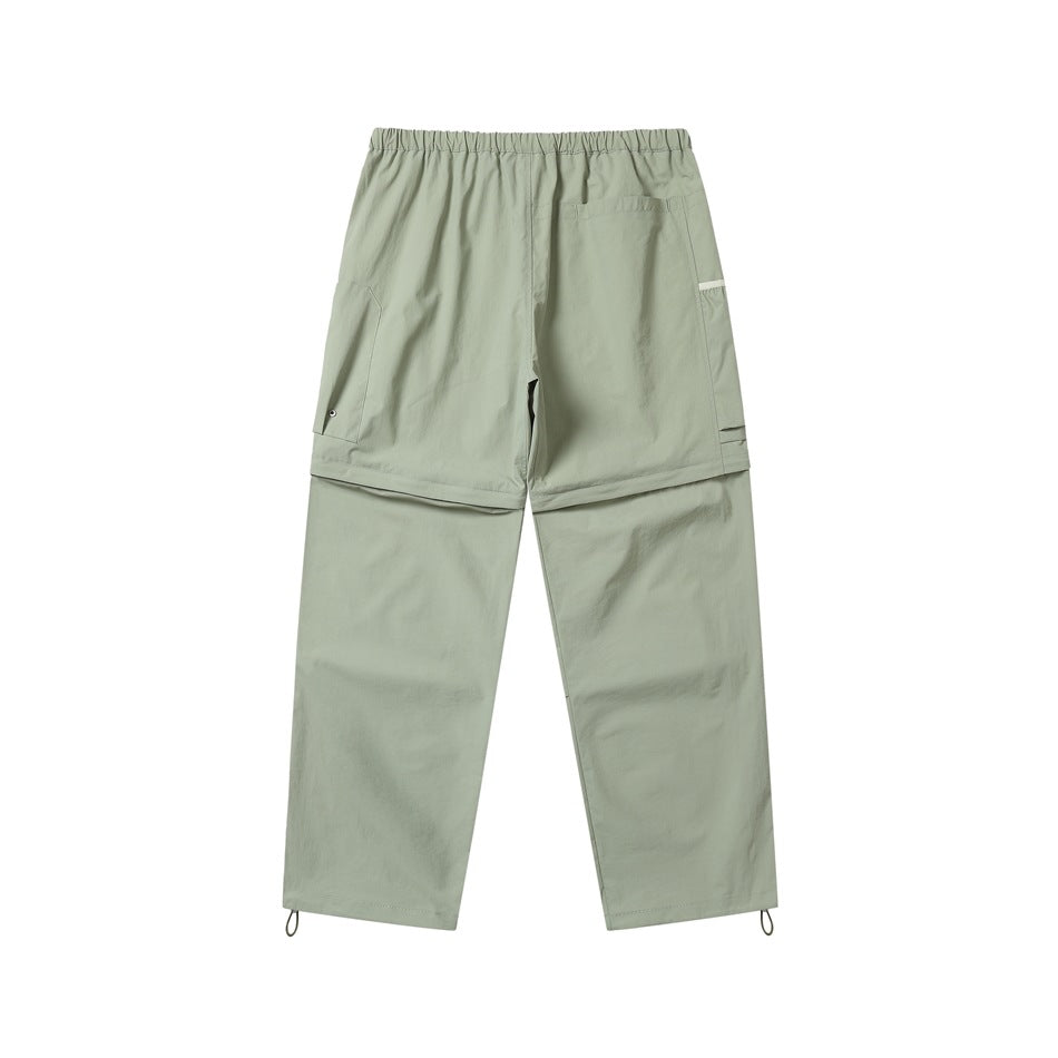 Back view of pale sage-green convertible cargo pants with an elastic waist, cargo pockets and adjustable hems.