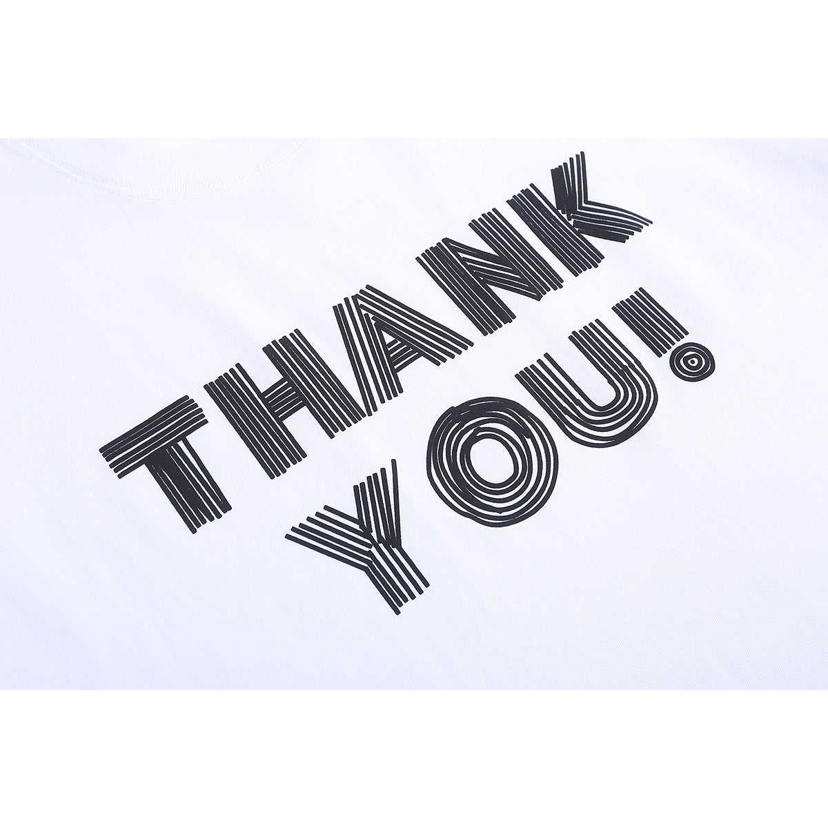 Close-up of a white T-shirt with bold black striped lettering reading “THANK YOU!”