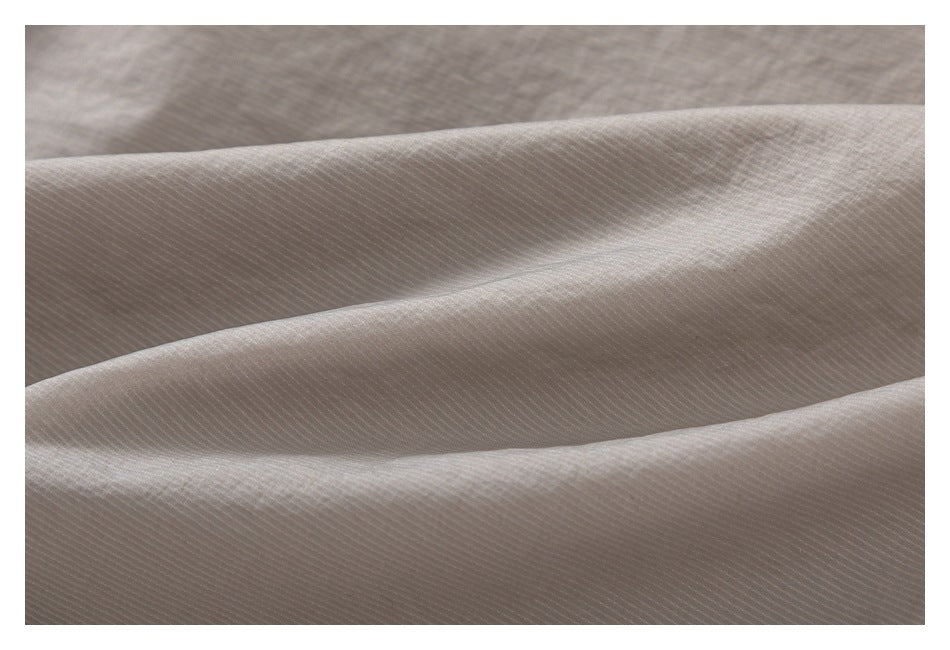 Macro view of taupe fabric showing its fine diagonal surface texture.
