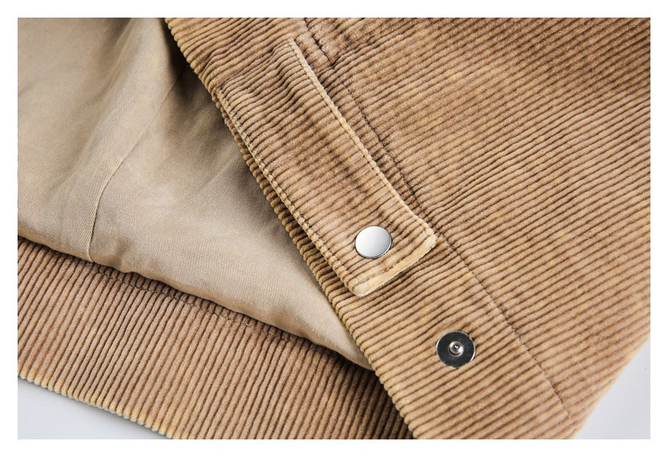 Close-up of tan corduroy fabric, a silver snap tab, and beige lining.