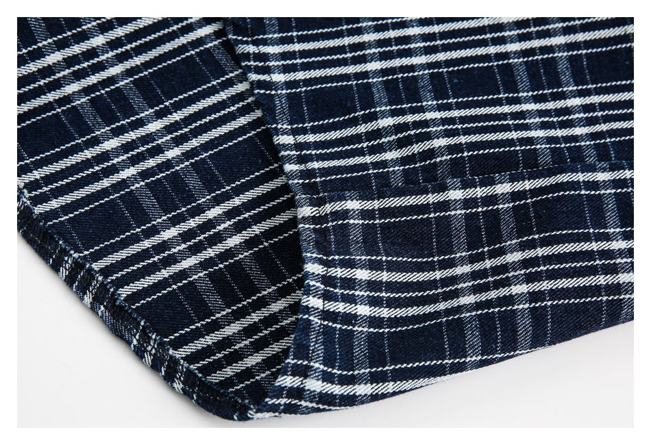 Close-up of the navy-and-white plaid shirt's stitched hem and folded fabric edge.