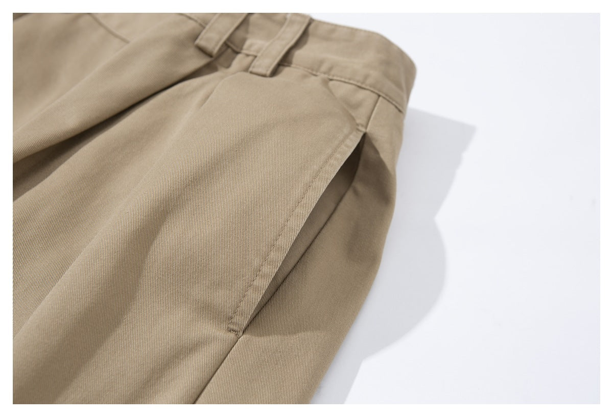 Close-up of tan trousers showing the waistband and side seam with a pocket opening.