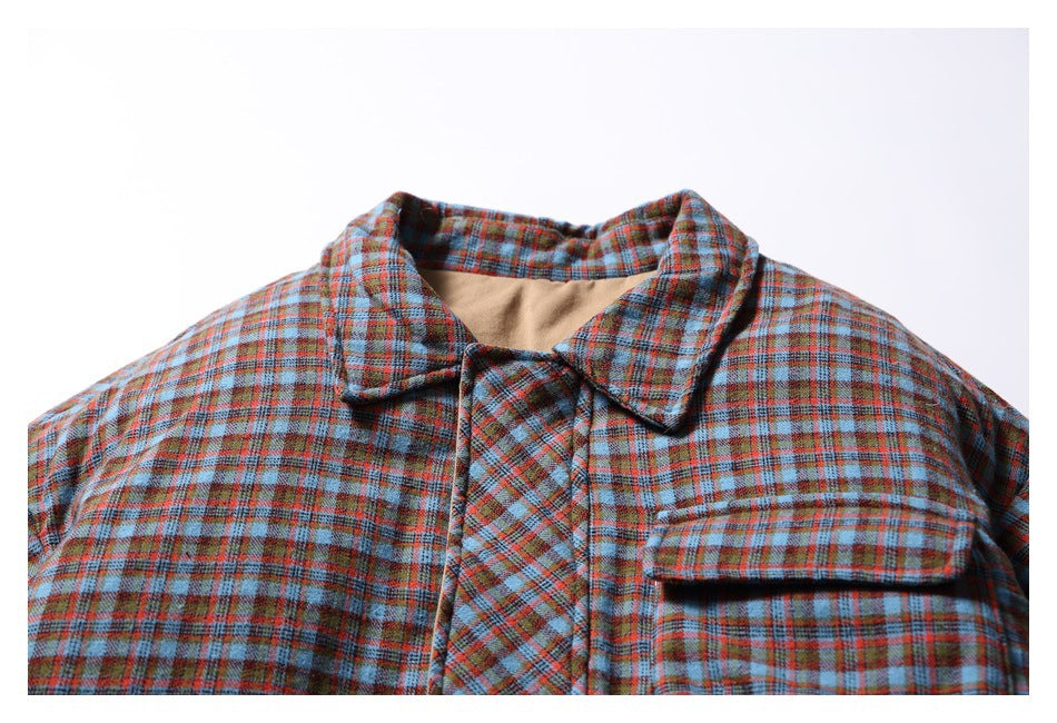 Close-up of the plaid jacket's collar, concealed front closure and flap chest pocket.