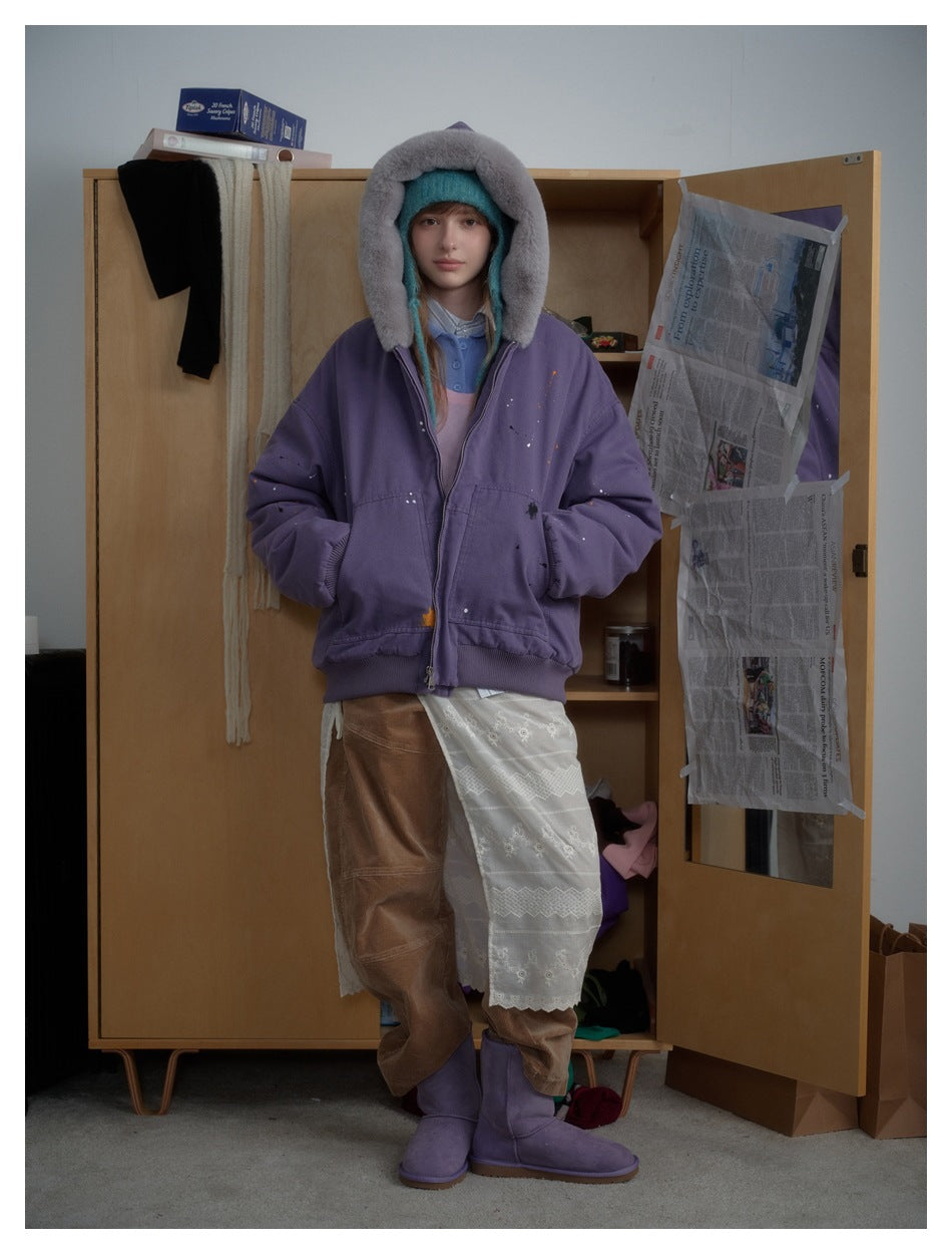 Full-length model wearing a purple jacket with the gray plush-lined hood raised.