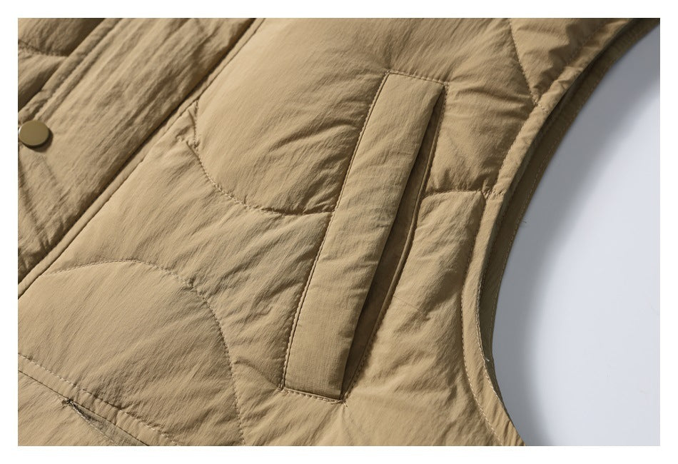 Close-up of a vertical welt pocket and curved quilting on the tan vest.