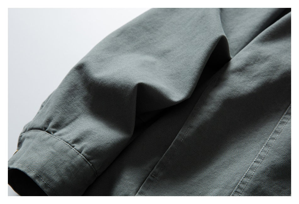 Close-up of the gray-green jacket sleeve and body, highlighting the fabric texture and seam stitching.