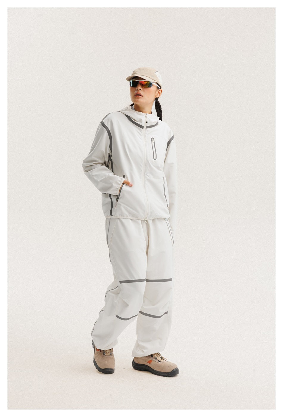 Model in a white hooded jacket and matching loose pants with gray accent details.