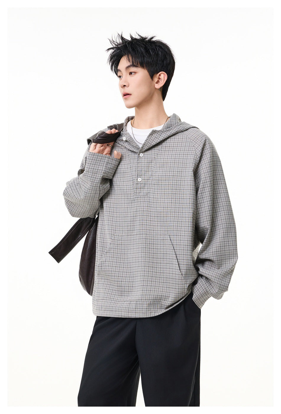 Side view of a model wearing a gray micro-check hooded pullover with a button placket and kangaroo pocket.