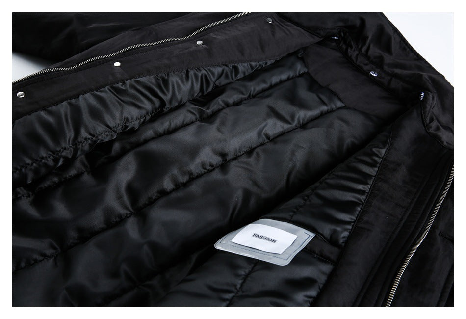 Close-up of a black coat's quilted satin lining, zipper, snaps, and a small sewn-in FASHION label.