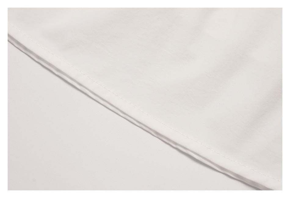 Close-up of the white skirt's curved hem and stitching.