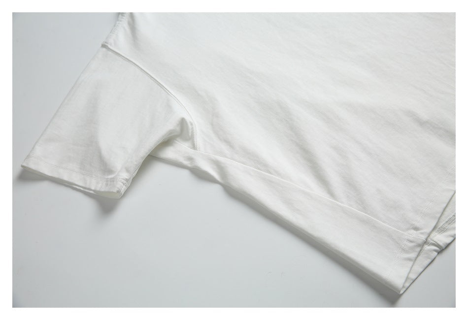 Close-up of a white T-shirt sleeve and side seam laid flat.