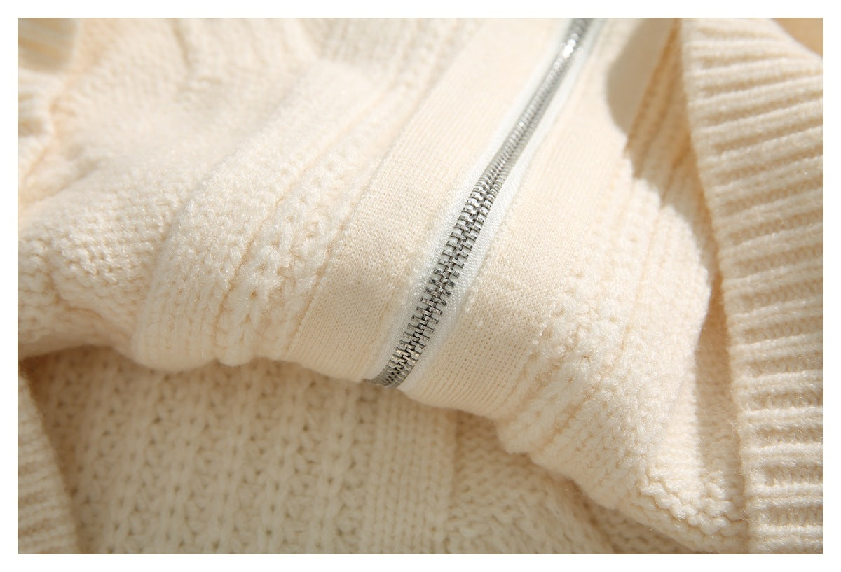 Close-up of a silver zipper set into the cream knitted sweater.