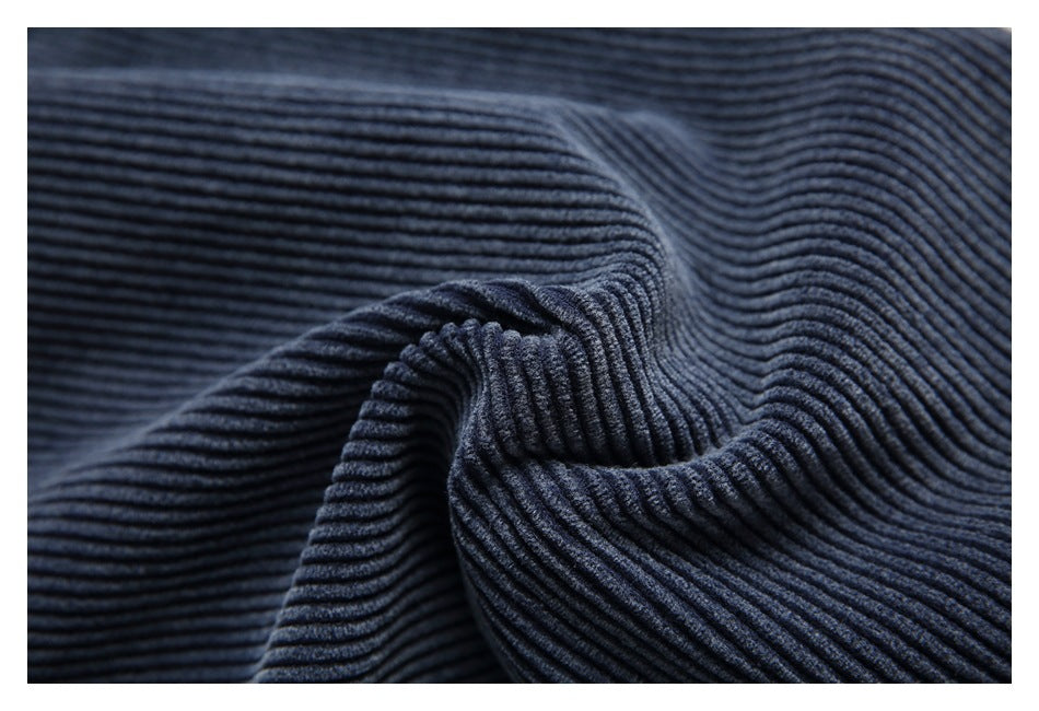 Macro view of the raised ribbed texture of navy corduroy fabric.