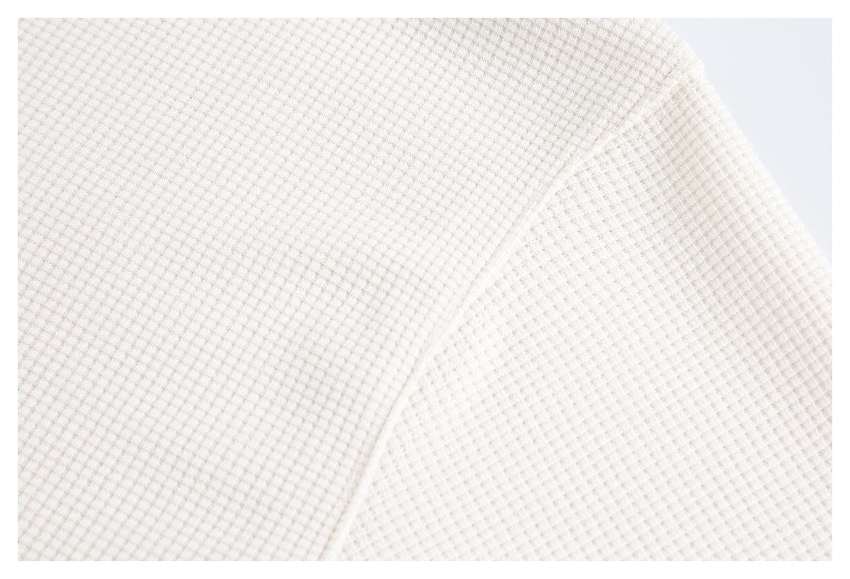 Close-up of the off-white garment's waffle texture and curved seam.