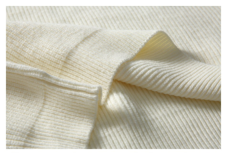 Close-up of the ivory cardigan's ribbed knit fabric and folded sleeve cuff.