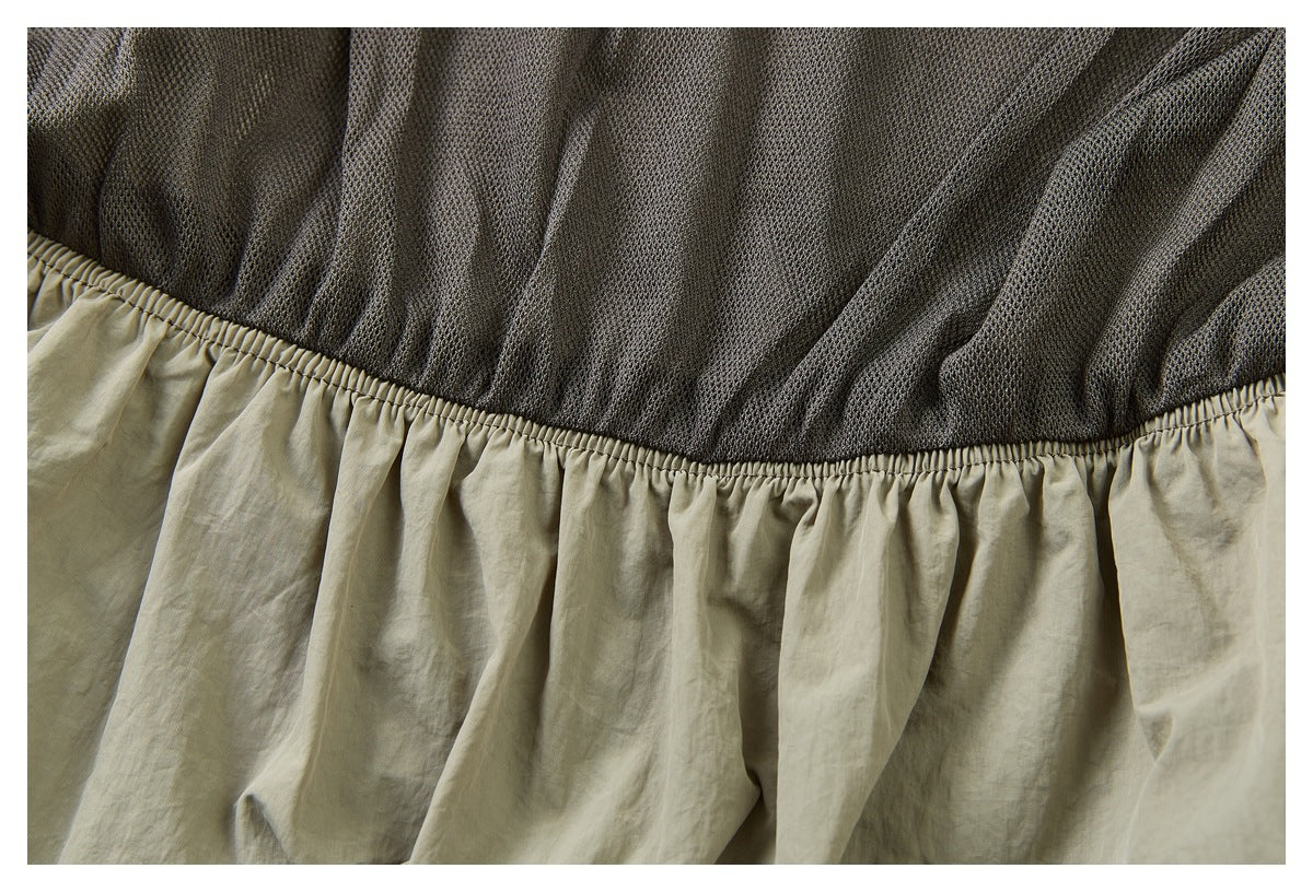 Close-up of dark mesh lining joined to the gathered waistband of khaki shorts.