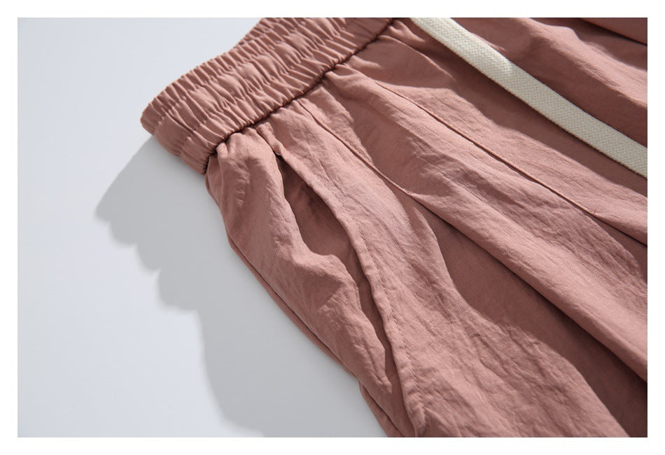 Close-up of a side pocket, waistband, and stitching on the dusty rose pants.