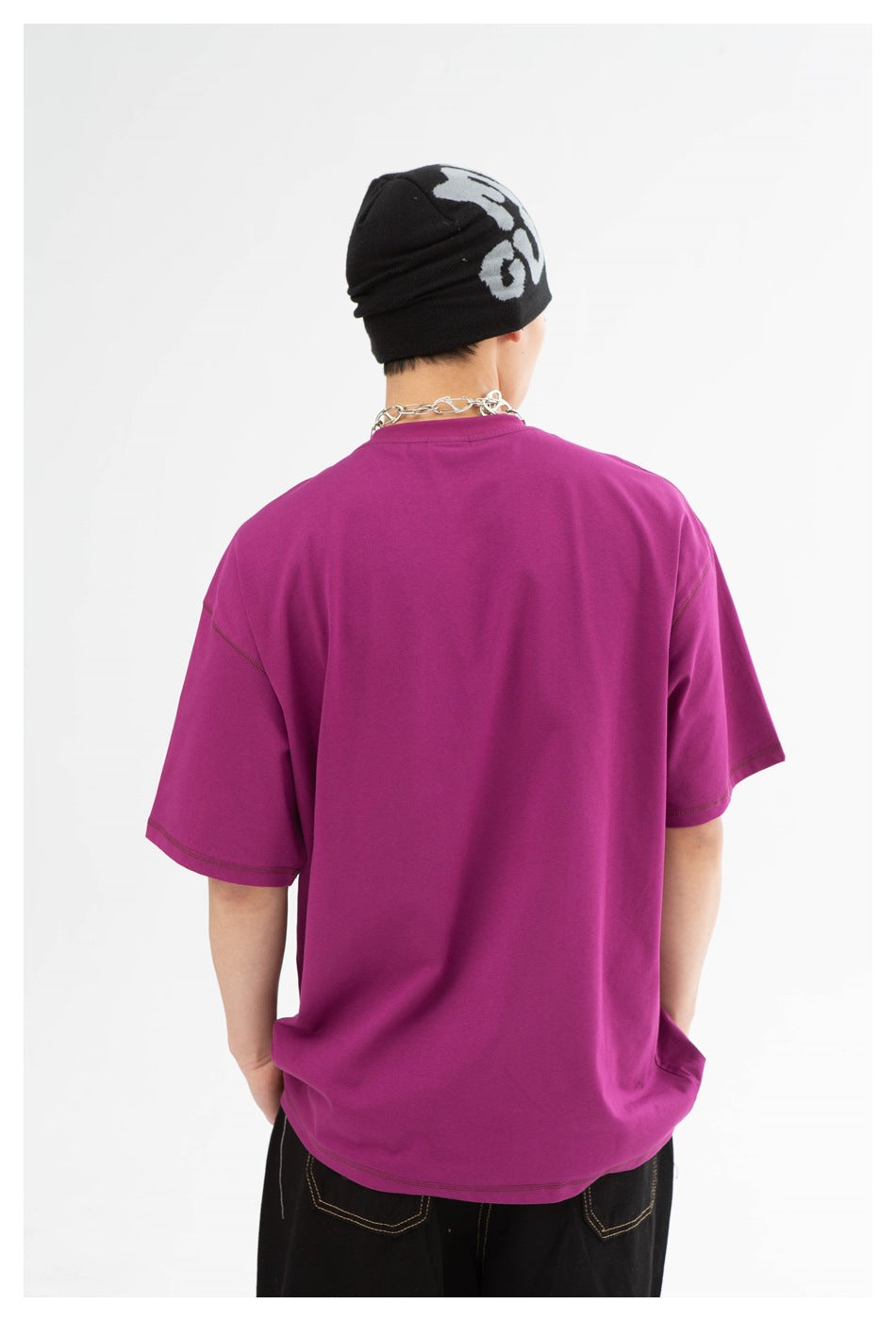 Back view of a model wearing a plain magenta oversized T-shirt.