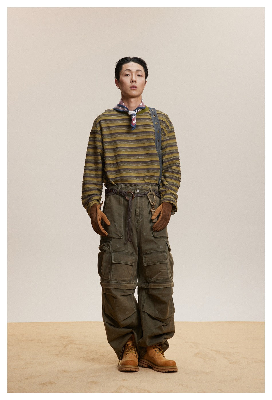 Model wearing green striped long-sleeve top with olive cargo pants, neckerchief and tan boots, front view