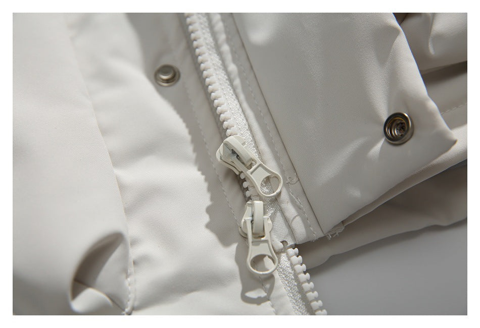 Close-up of a white jacket's chunky zipper with two pulls and metal snap fasteners.