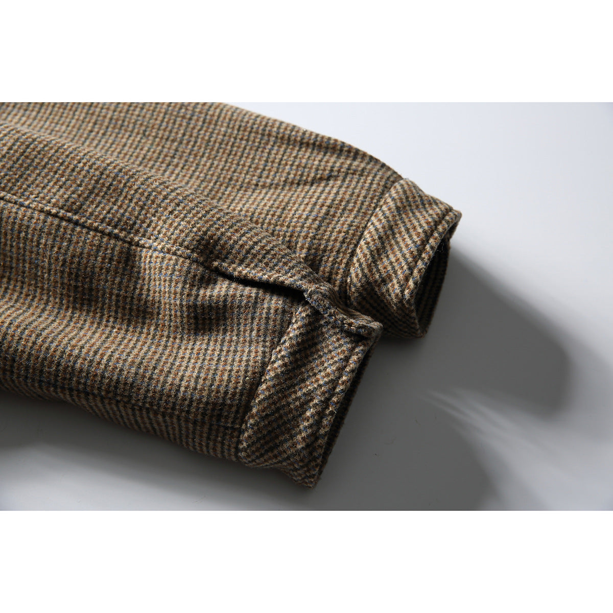 Close-up of the checked jacket's sleeve cuff and button-tab detail.