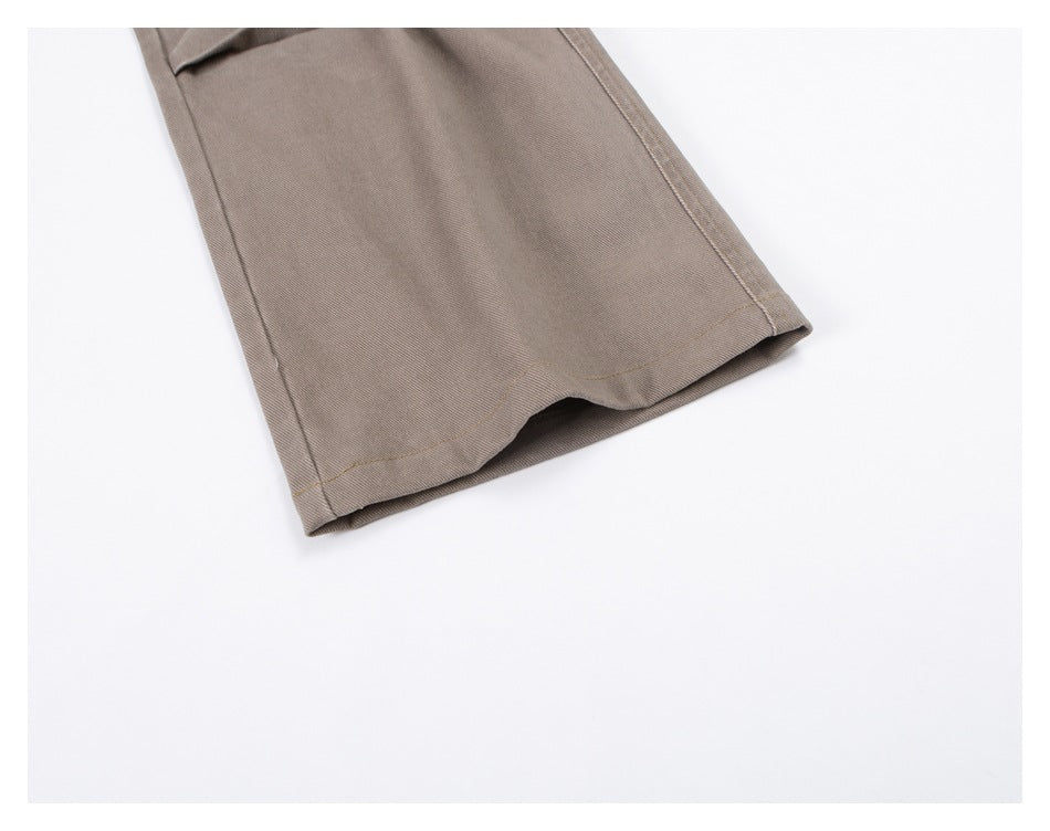 Close-up of the stitched hem on a taupe garment leg against a white background.