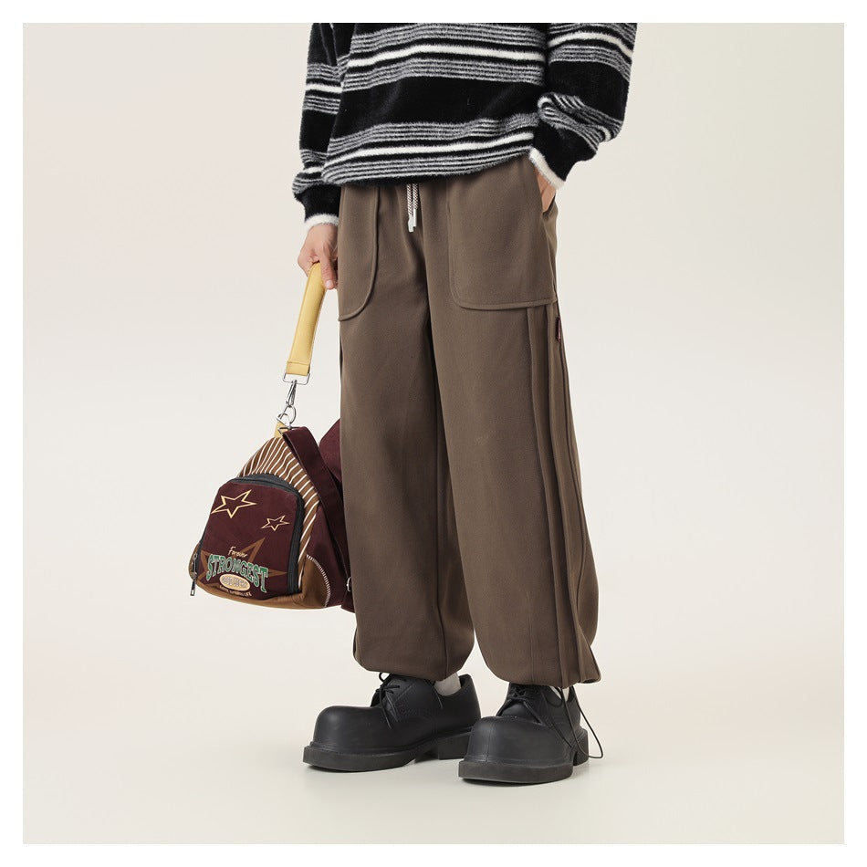 Front view of brown cargo pants worn with a striped sweater; the model carries a burgundy shoulder bag.