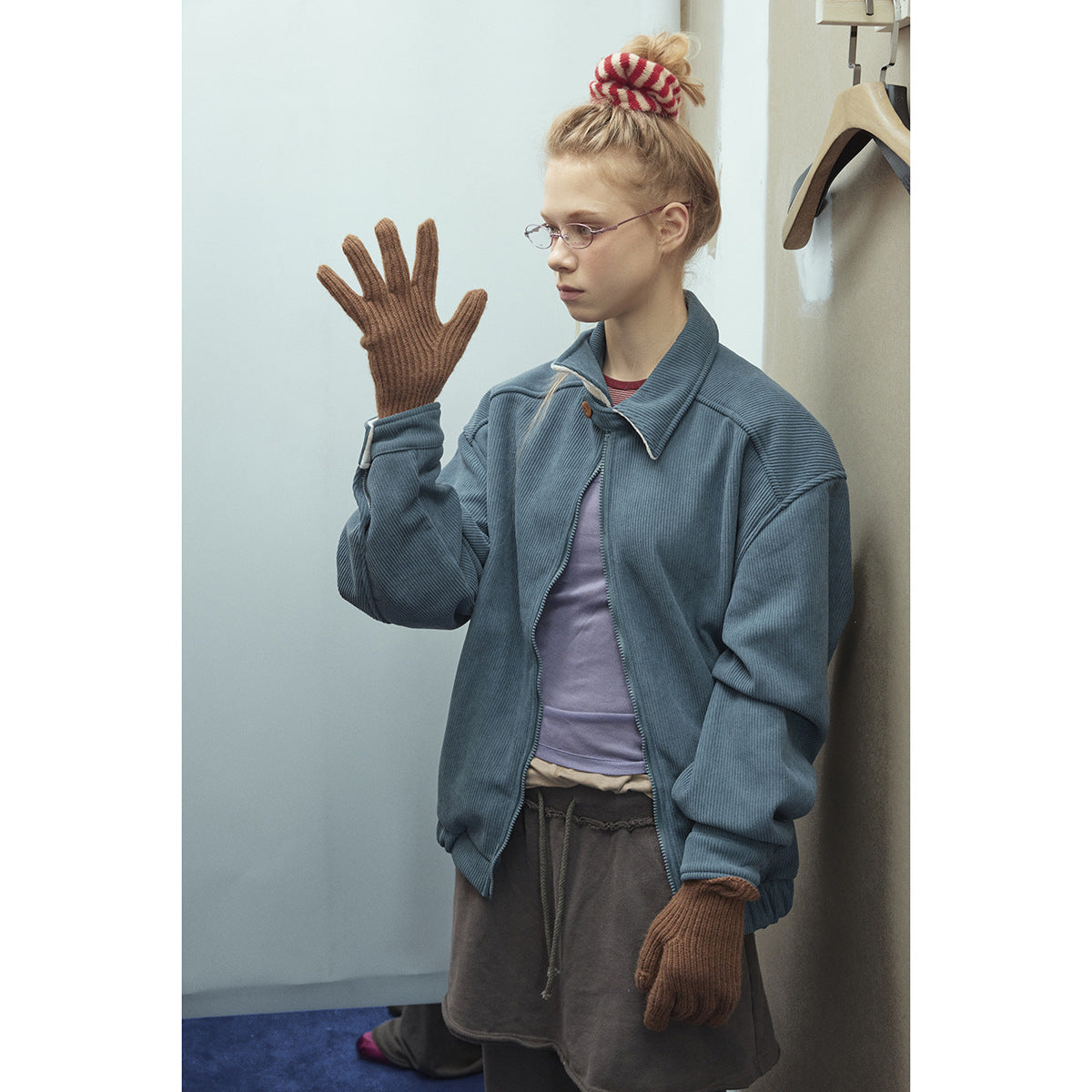 Model wearing an oversized blue-gray zip jacket with a wide collar and ribbed texture.