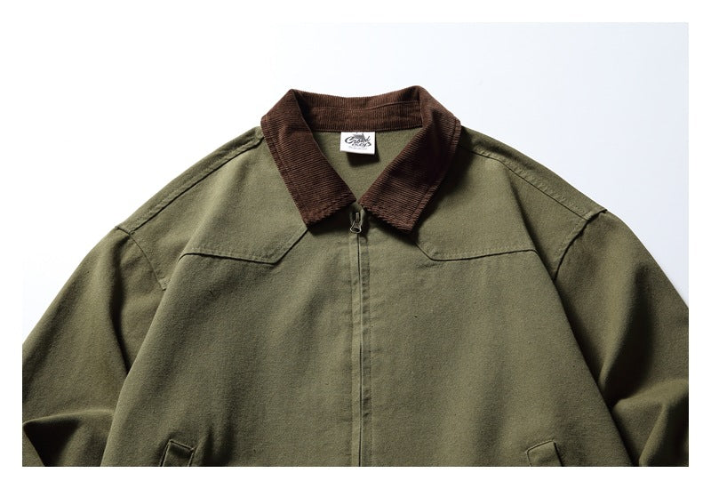 Upper front of an olive jacket showing a brown collar, center zipper, shoulder seams, and a small neck label.