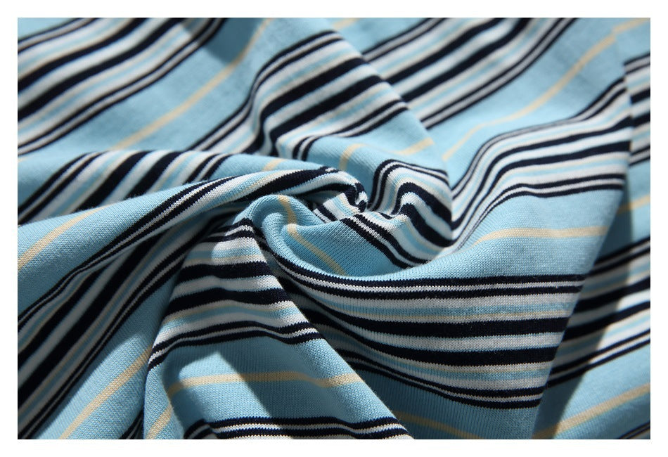 Close-up of light blue striped knit fabric gathered into a twist, showing black, white, and thin tan stripes.
